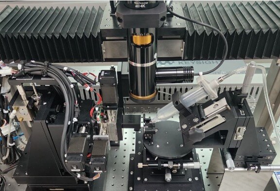 Axis-Tec PIC test area showing PEAKQUEST manipulators, microscope and device fixture